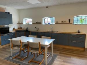 a kitchen with blue cabinets and a table and chairs at Højmosegård værelse 1 in Varde