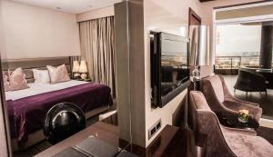 a hotel room with a bed and a flat screen tv at Coastlands Musgrave Hotel in Durban