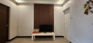 a room with a table with a television on it at Kuya and Kambal's 1 BR 1 Bath Apartment in Manila
