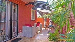 a patio with two white chairs and a red wall at Palawan Villa Vacation HOME in Puerto Princesa City