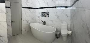 Un baño blanco con bañera y inodoro. en Entire home in Lawndale Los Angeles, en Lawndale 27 fotos más