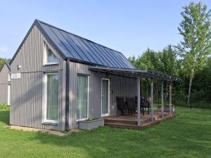 a metal building with a deck and a house at Rietumi in Kolka