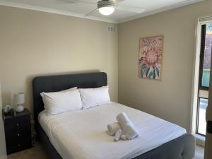 a bedroom with a bed with two stuffed animals on it at Waterside Mulwala in Mulwala