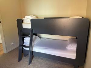 a black bunk bed with white sheets and towels at Waterside Mulwala in Mulwala