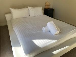 a white bed with two rolled towels on it at Waterside Mulwala in Mulwala