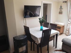 a dining room with a table and chairs and a television at Emma's BNB in Kempton Park