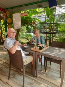 two men sitting at a table in a restaurant at Dream Vision Guest House in Diu