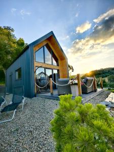 a tiny house with a large window and chairs at Repakowa Chata in Polańczyk +32 photos