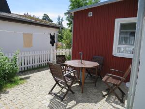 a patio with a table and chairs next to a red building at Strandhaus am Oberuckersee in Warnitz