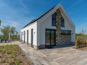 a white building with glass doors on a patio at Getaway with Bubble Bath in Oudeschild