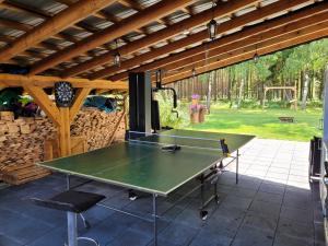 a ping pong table on a patio under a roof at Letniskowy domek z Bali in Myszyniec