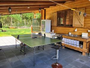 a ping pong table in the kitchen of a cabin at Letniskowy domek z Bali in Myszyniec