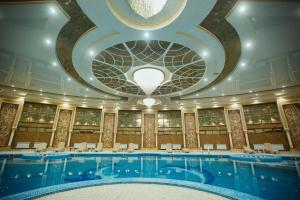 a large swimming pool with a domed ceiling at Antalya Grand Palace Hotel in Urganch