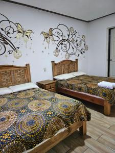 a bedroom with two beds and a chandelier at Posada villa aurora in Bernal