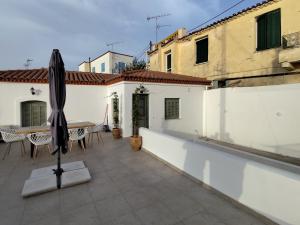 a patio with a table and an umbrella on a building at Xasteria apartment Ξαστεριά in Poros +9 photos