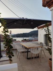a table and chairs with an umbrella on a patio at Xasteria apartment Ξαστεριά in Poros