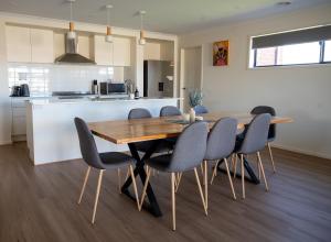 a kitchen and dining room with a wooden table and chairs at Grevillea House in Echuca