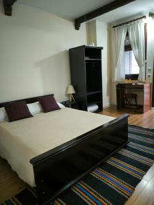 een slaapkamer met een groot bed en een bureau bij Андреева къща in Zlatograd +14 foto's