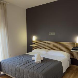 a bedroom with a large bed with two towels on it at Hotel Quadrifoglio in Caraglio