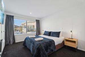 a bedroom with a bed and a large window at Alpine Retreat - 3 Bedroom in Wanaka +14 photos