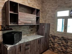 a kitchen with wooden cabinets and a microwave at Nile view panoramic balcony in Cairo
