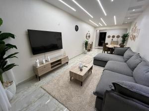 a living room with a couch and a flat screen tv at Nile view panoramic balcony in Cairo