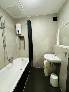 um banheiro com banheira, pia e vaso sanitário em Zentrale Wohnung mit Balkon em Koblenz