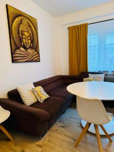 uma sala de estar com um sofá castanho e uma mesa em Zentrale Wohnung mit Balkon em Koblenz