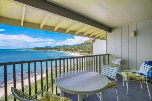 卡帕阿Charming Wailua Bay View Oceanfront Top Floor with an Amazing View!的带桌椅和海景的阳台