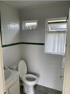 a bathroom with a toilet and a sink and a window at Little Spain in Selsey