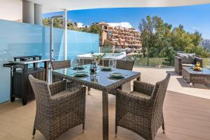 a table and chairs on a patio with a grill at Amazing sea view from the comfort of the jacuzzi in Fuengirola