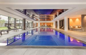 an indoor swimming pool with blue water in a building at Rivage Hôtel & Spa Annecy in Annecy