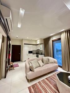 a living room with a couch and a kitchen at 2 Hawana VIP Studio in Ma‘mūrah