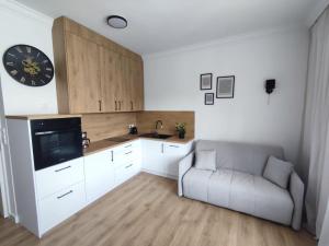 a kitchen with a couch and a clock on the wall at Plac Pilsudskiego in Opole