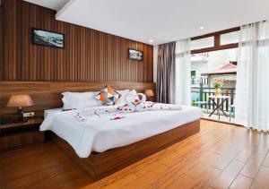 a bedroom with a large bed and a balcony at Hanoi Old Quarter Hotel & Travel in Hanoi