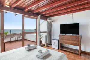 a living room with a television and a bed with towels at Casa Roque in Haría
