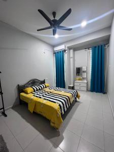a bedroom with a bed and a ceiling fan at Amara Homestay Kuantan in Kampong Bugis