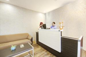 a man standing at a counter with a laptop at Limewood stay Service Apartments Golf Course Road in Gurgaon