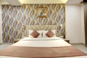 a bedroom with a large bed with a wall at Limewood stay Service Apartments Golf Course Road in Gurgaon +58 photos