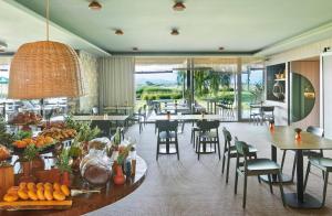 a restaurant with tables and chairs and a large window at Empordà Golf Resort in Torroella de Montgrí