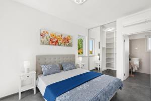 a bedroom with a bed with a blue comforter at Beautiful Villa Brtonigla with pool in Brtonigla in Brtonigla +43 photos
