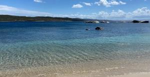 un bacino d'acqua con spiaggia e rocce di Villa pieds dans l'eau sur la plage a Pianottoli-Caldarello