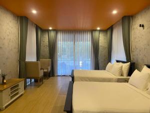 ein Hotelzimmer mit zwei Betten und einem Fenster in der Unterkunft BaHo Eco Beat in Ninh Hòa