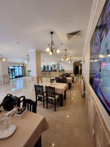 a restaurant with tables and chairs and a large screen at Famagusta Antoniya in Aheloy