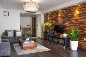 a living room with a couch and a tv at Viet Vuong Building Ha Noi Capital in Hanoi