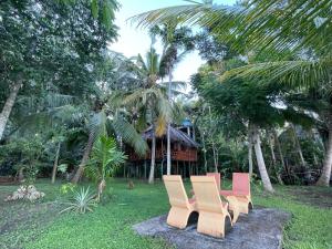 a group of chairs sitting in a yard with palm trees at LakeSide Cabana Tissamaharama in Tissamaharama