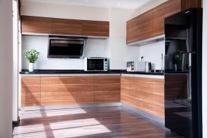 a kitchen with wooden cabinets and a microwave oven at Viet Vuong Building Ha Noi Capital in Hanoi +40 photos