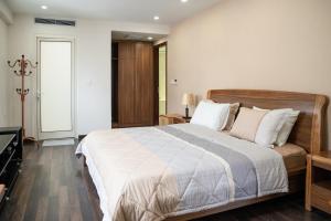 a bedroom with a large bed with white sheets at Viet Vuong Building Ha Noi Capital in Hanoi