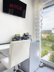 a white chair in front of a desk and a window at Chambre à Antony proche de Paris et à 10 minutes aéroport Orly in Antony