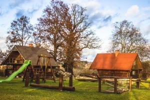a playground with a log house and a slide at Leisure Center Turbas in Turkalne